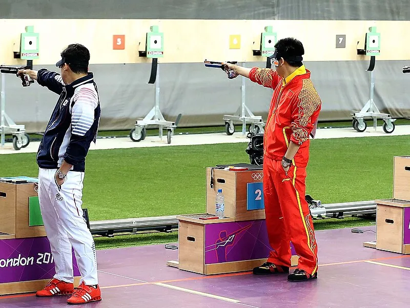 Three Olympic pistol shooters competing on the range at London 2012